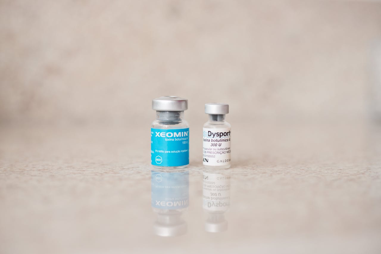 journey Close-up of Xeomin and Dysport bottles reflecting on a surface, shot indoors.